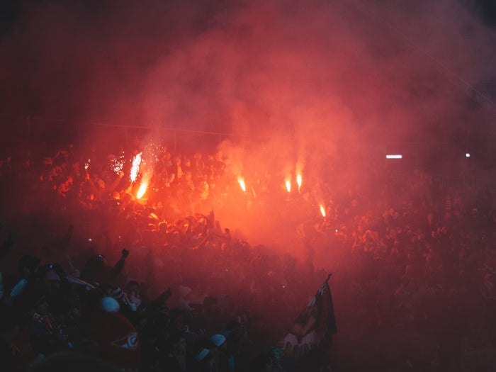 Stimmungsvolle Tribünenatmosphäre mit Licht und Rauch